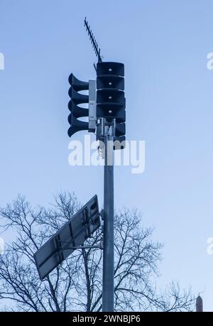 Solar-powered horn loudspeakers pole. Dawn blue light background Stock Photo