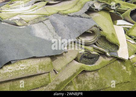 Used artificial grass rolls and patches stacked. Refurbishing waste disposal Stock Photo