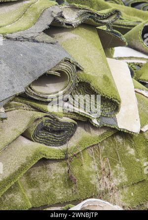 Used artificial grass rolls and patches stacked. Refurbishing waste disposal Stock Photo