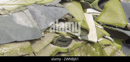 Used artificial grass rolls and patches stacked. Refurbishing waste disposal Stock Photo