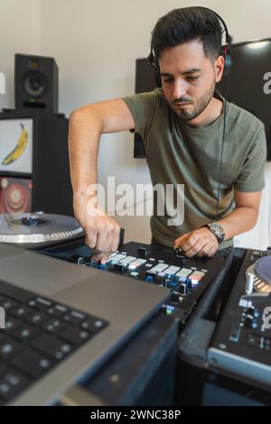 DJ having a good time while pressing buttons on the console to create music. Stock Photo