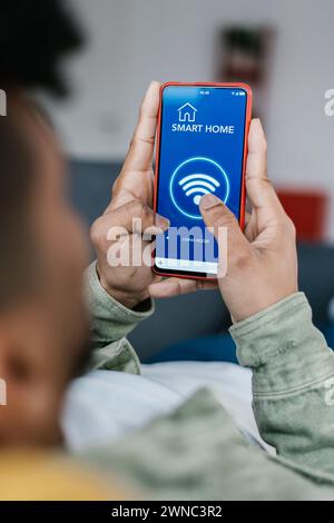 Close-up view of young man connecting smart phone to wifi at home Stock Photo
