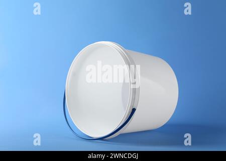 One empty plastic bucket on light blue background Stock Photo