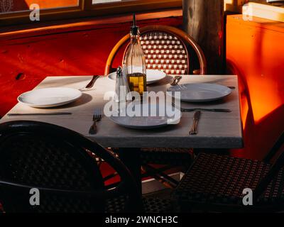 Empty outdoor restaurant table set with white plates in Manhattan, New York City, USA. Stock Photo