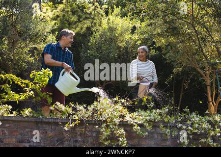 Senior biracial woman and man are tending to garden plants Stock Photo