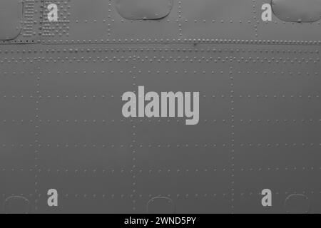 Aircraft skin close up. Rivets on gray metal. Aluminum surface of the aircraft fuselage. Stock Photo