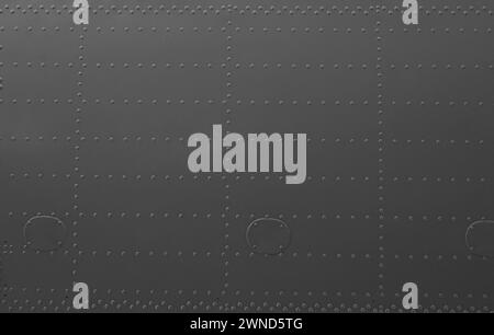 Aircraft skin close up. Rivets on gray metal. Iron panel of airplane. Stock Photo