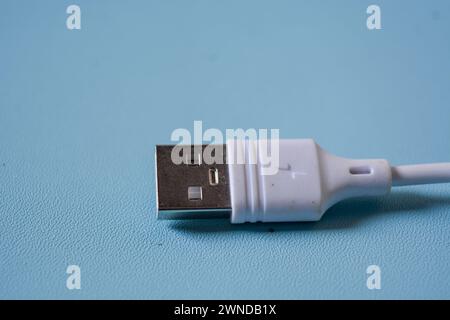White folded usb and micro usb cable on blue background. Stock Photo
