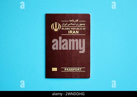 Red Islamic Republic of Iran passport on blue background close up. Tourism and citizenship concept Stock Photo