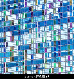 A wall of many windows and reflections, looking up at the exterior of contemporary architecture. Colourful blue tones. Architectural abstract backgrou Stock Photo