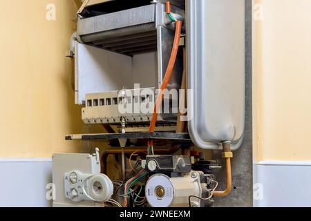 Professionally qualified engineers are engaged in the repair of gas water heater boilers in homes Stock Photo