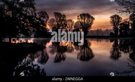 Tranquil scene of a lake with trees and sunset, reflections on the water at dusk, Bamberg Burger Spitze Stock Photo
