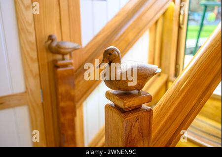 Two carved wooden ducks on the newel posts on a staircase on a canal boat called drake. Stock Photo