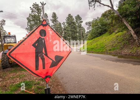Los Angeles, CA, USA – March 1, 2024: Close-up of a bright orange road work sign at the Hollywood Lake reservoir in Los Angeles, CA. Stock Photo
