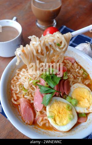 Photo of noodle soup with toppings such as sausages, eggs, and vegetables Stock Photo