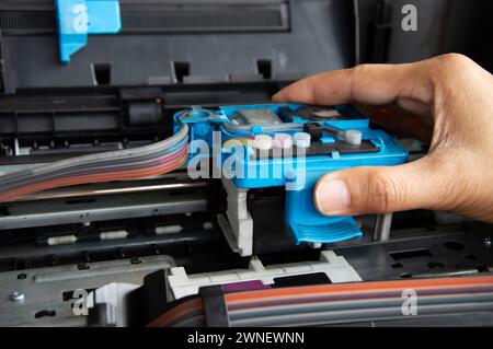 Technician repairing printer, fixing printer head Stock Photo