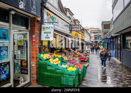 Boz's Fruit & Veg greengrocery shop in Church Path, Woking, with a colourful display of fresh produce outside, seen on a wet, rainy day Stock Photo