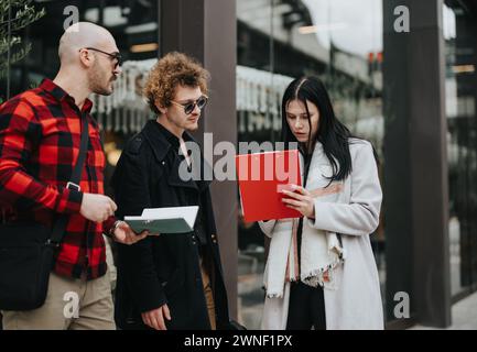 Business colleagues discussing work-related matters outdoors with focus and determination Stock Photo