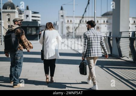 Young business professionals walking in urban city area discussing strategies and marketing. Stock Photo