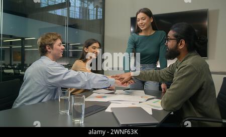 Happy business people women men stacking hands in pile together at office multi ethnic colleagues businessmen businesswomen corporate creative team Stock Photo