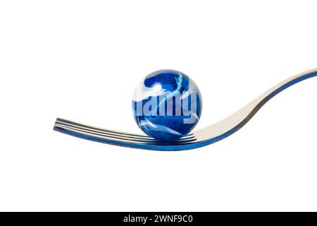 A blue and white swirl glass marble on a fork. Stock Photo