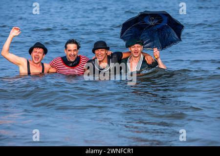 Heringsdorf, Germany. 02nd Mar, 2024. Actors Oliver Mommsen (r), Roman Knizka (2nd from right), Bernhard Bettermann (2nd from left) and Hendrik Duryn (l) take a dip in the water of the Baltic Sea in historical costumes after the 'Baltic Lights' sled dog race. To collect donations for Welthungerhilfe, professionals and celebrities compete against each other in teams of 500 huskies on the beach. Credit: Jens Büttner/dpa/Alamy Live News Stock Photo