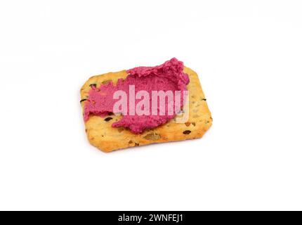 Beet hummus spread on a cracker isolated on white background Stock Photo