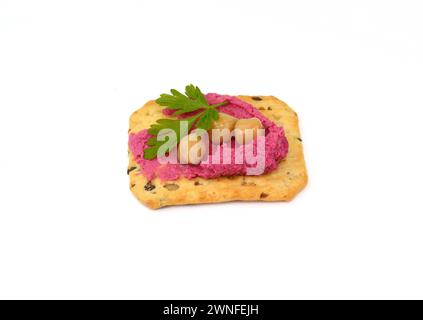Beet hummus spread on a cracker isolated on white background Stock Photo