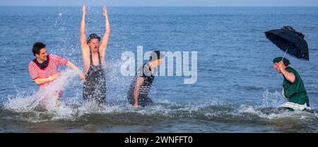 Heringsdorf, Germany. 02nd Mar, 2024. Actors Oliver Mommsen (l), Roman Knizka (2nd from left), Bernhard Bettermann (2nd from right) and Hendrik Duryn (r) take a dip in the water of the Baltic Sea in historical costumes after the 'Baltic Lights' sled dog race. To collect donations for Welthungerhilfe, professionals and celebrities compete against each other in teams of 500 huskies on the beach. Credit: Jens Büttner/dpa/Alamy Live News Stock Photo