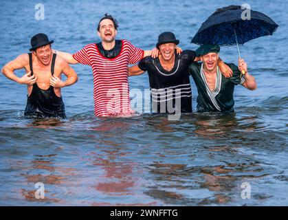 Heringsdorf, Germany. 02nd Mar, 2024. Actors Oliver Mommsen (2nd from left), Roman Knizka (l), Bernhard Bettermann (2nd from right) and Hendrik Duryn (r) take a dip in the water of the Baltic Sea in historical costumes after the 'Baltic Lights' sled dog race. To collect donations for Welthungerhilfe, professionals and celebrities compete against each other in teams of 500 huskies on the beach. Credit: Jens Büttner/dpa/Alamy Live News Stock Photo