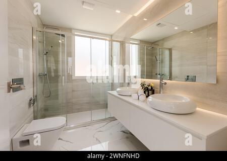 an image of a large double bathroom with standing shower and twin sinks in mediterranean real estate Stock Photo