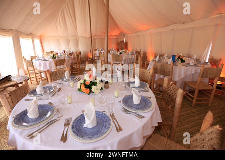 The interior of a kanvas tent ready to typical  banquet in Agafay Desert near Marrakesh, Morocco Stock Photo