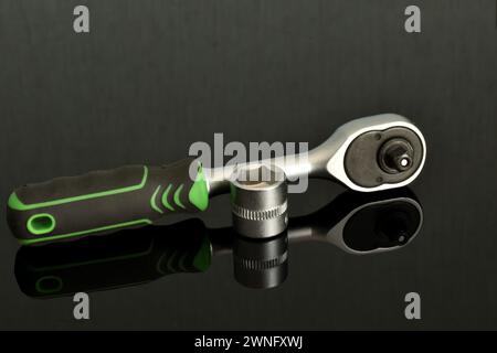 Socket wrench with ratchet with one head on a dark background. Stock Photo