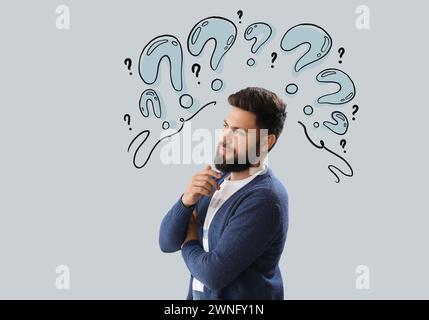 Thoughtful young bearded man on light background Stock Photo