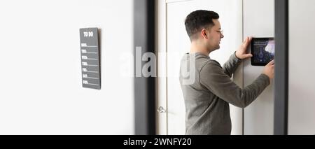 Man using smart home security system indoors Stock Photo