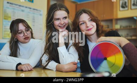 Students in physics class spin Newton's colorful wheel. Stock Photo