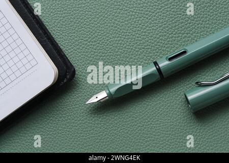 Fountain pen and notebook green leather background Stock Photo