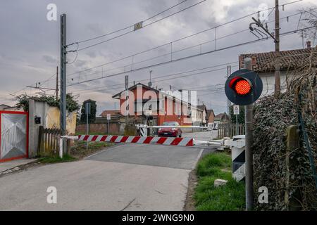Sommariva del Bosco, Italy - March 02, 2024: Level crossing closed with red light on SFM4 Alba - Turin - Caselle Airport railway line Stock Photo