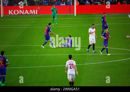 SERGIO BUSQUETS, MESSI, BARCELONA FC, 2017: Sergio Busquetshelps Lionel Messi to his feet after a foul. Barcelona FC v Sevilla FC at Camp Nou, Barcelona on 5 April 2017. Photo: Rob Watkins. Barca won the game 3-0 with three goals in the first 33 minutes. The game was played in a deluge of rain during a massive spring storm. Stock Photo