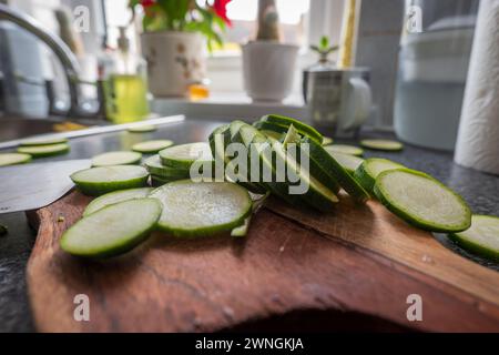 Chopped courgette slices on a wooden cutting board. Stock Photo