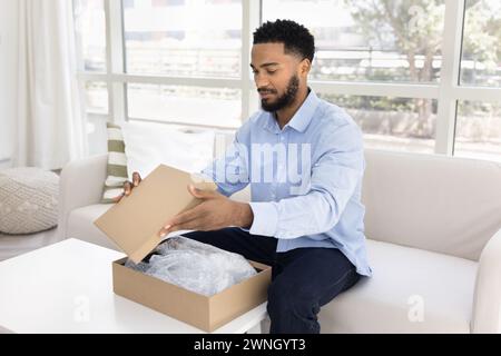 Handsome young African American customer man receiving purchase Stock Photo