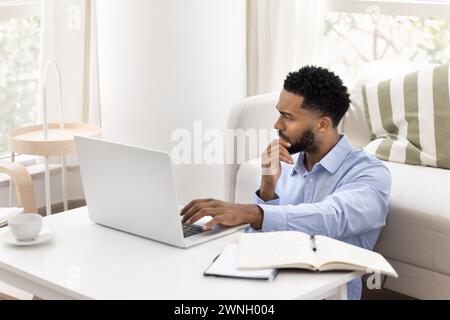 Concerned young African freelancer man thinking on business project Stock Photo