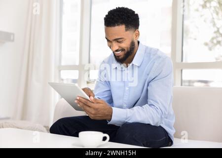Happy young African entrepreneur man enjoying Internet technology Stock Photo