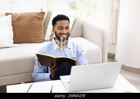 Happy positive young Black student guy studying online at home Stock Photo