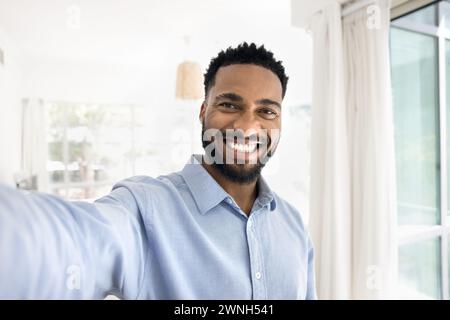 Cheerful handsome young African man taking selfie, looking at camera Stock Photo