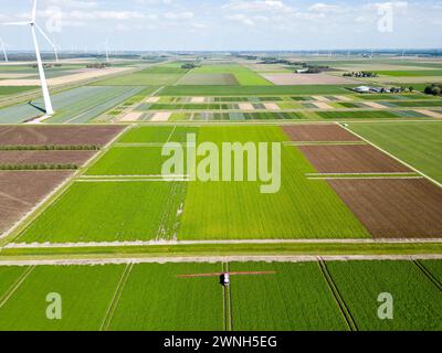 Aerial view of a machine spraying chemical additives on crops in an agricultural field Stock Photo