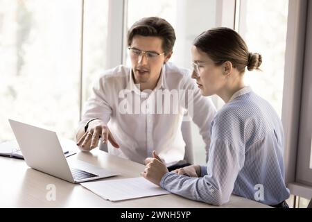 Two workmates talking, working together on joint online project Stock Photo