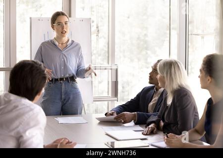 Young female business coach makes presentation during formal meeting Stock Photo