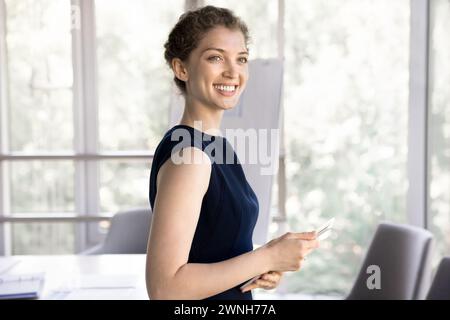 Young happy businesswoman posing in office with digital tablet Stock Photo