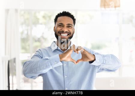 Positive attractive young African man making hand heart gesture Stock Photo